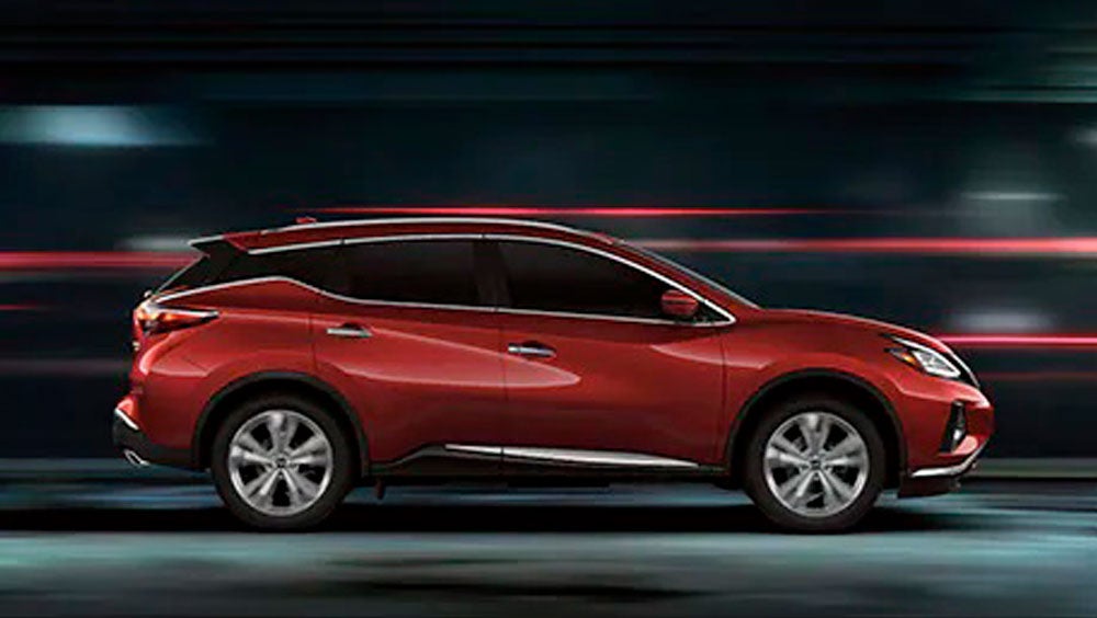 2023 Nissan Murano shown in profile driving down a street at night illustrating performance. | Cherokee County Nissan in Holly Springs GA